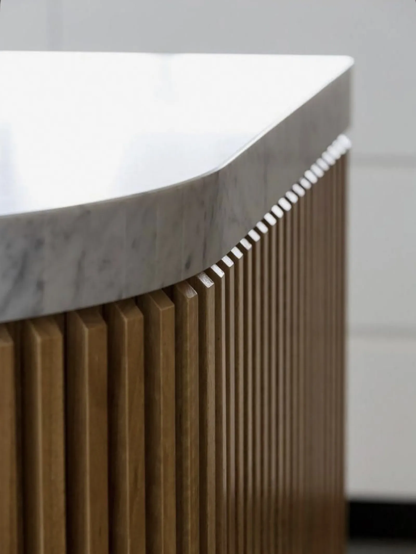 Détail d'un pied de meuble cannelé sous un plateau en marbre